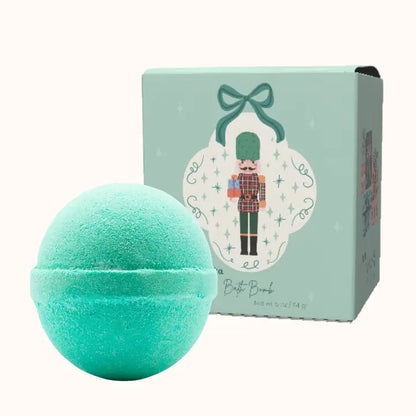 Turquoise bath bomb with a decorative box featuring a nutcracker design on a white background