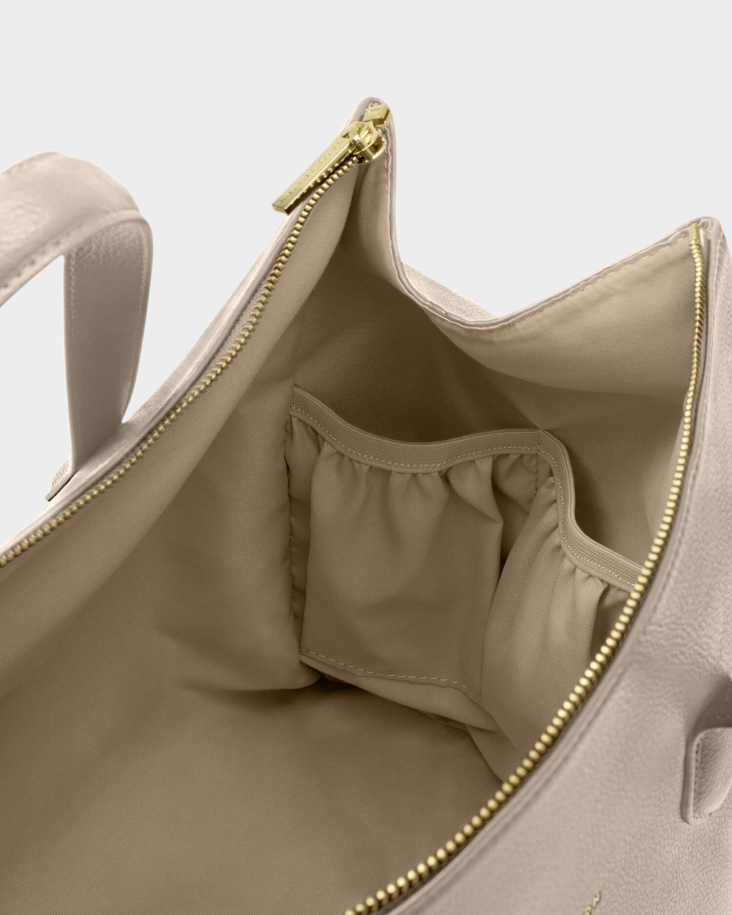 Interior of Katie Loxton Milan Cabin Bag in Oyster showing elasticated storage pockets and zip closure in vegan leather travel bag.